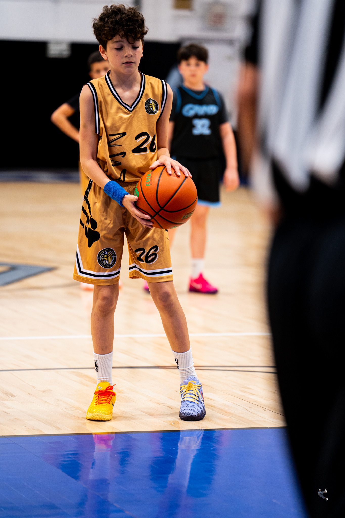 Young athlete in a gold ZSA jersey lining up a free throw
