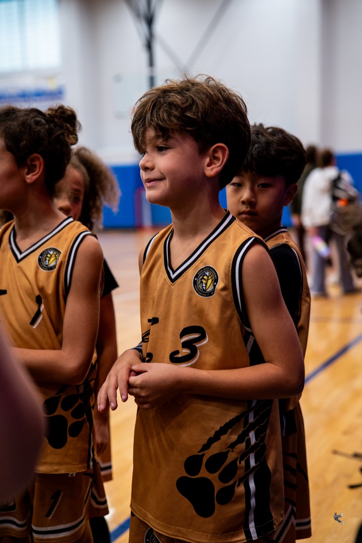 Young Zion players in gold jerseys smiling on the court